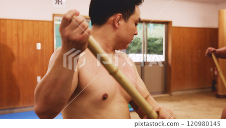 Sumo, wrestler and man sweeping, cleaning and ritual purification process in dohyo ring. Japanese tradition, culture and prepare arena with broom for spiritual custom, respect and safety for sports 120980145