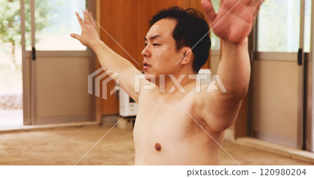 Man, training and exercise for sumo, fitness and exercise with preparation, stretching and technique in Japan. Athlete, fighter and sports in dohyo for practice, workout and wrestling with warm up Man, training and exercise for sumo, fitness and exercise with preparation, stretching and technique in Japan. Athlete, fighter and sports in dohyo for practice, workout and wrestling with warm up 120980204