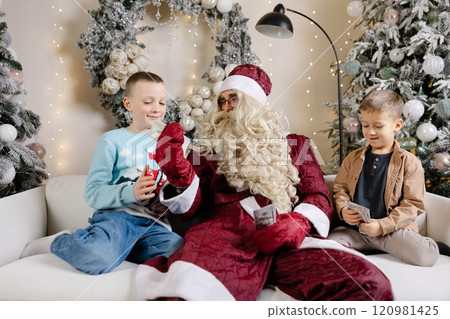 Santa claus giving money to children on christmas day Santa claus giving money to children on christmas day 120981425