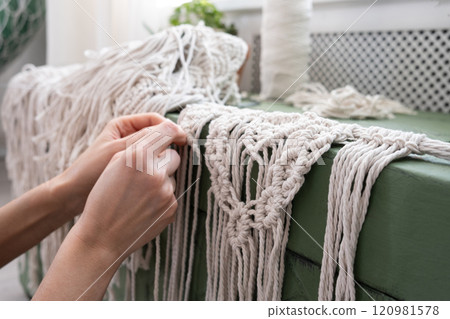 Woman weaves home Handmade decor from cotton thread macrame. Macrame panel creating process. Woman weaves home Handmade decor from cotton thread macrame. Macrame panel creating process. 120981578