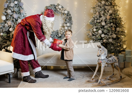 Santa claus giving christmas gift to child Santa claus giving christmas gift to child 120981608