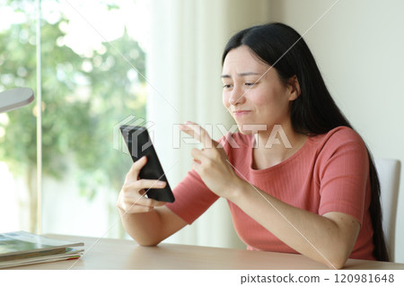 Doubtful asian woman crossing fingers checking phone Doubtful asian woman crossing fingers checking phone 120981648