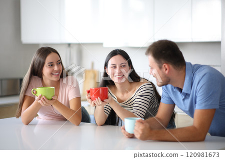 Three roommates talking at breakfast in the kitchen Three roommates talking at breakfast in the kitchen 120981673