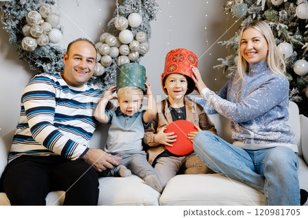 Family enjoys christmas morning, opening presents and laughing together 120981705