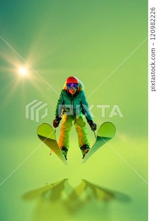 Skier performing impressive jump, frozen mid-air in green neon hues against studio background. Movement. 120982226