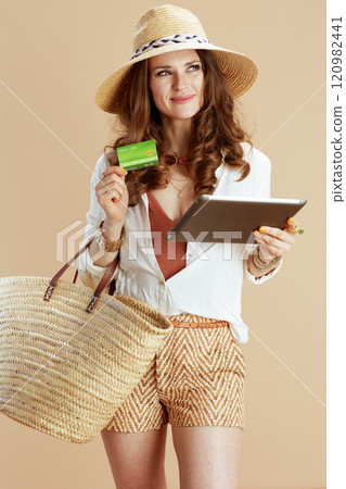 happy woman in blouse and shorts against beige 120982441