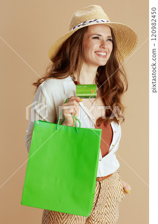 smiling elegant female in blouse and shorts against beige smiling elegant female in blouse and shorts against beige 120982450