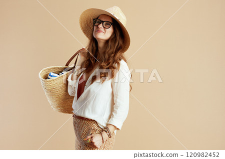 happy housewife in blouse and shorts against beige 120982452