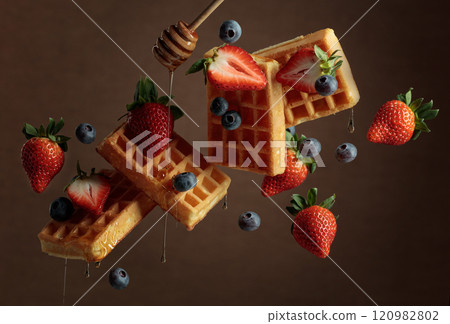 Waffles with blueberries, strawberries, and honey. 120982802