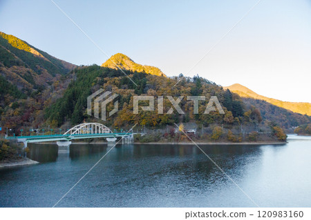 A bridge surrounded by autumn-colored mountains at Lake Okutama A bridge surrounded by autumn-colored mountains at Lake Okutama 120983160