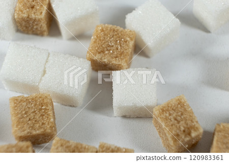 Cubes of unrefined brown demerara sugar and white refined beet sugar. Cubes of unrefined brown demerara sugar and white refined beet sugar. 120983361