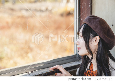 A young woman waiting for a bus at a bus stop. Photo courtesy of Ugo Kotsu. 120984048