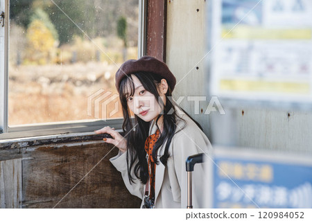 一名年輕女子在公車站等車 攝影由 Ugo Kotsu 提供。 一名年輕女子在公車站等車 攝影由 Ugo Kotsu 提供。 120984052
