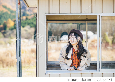 一名年輕女子在公車站等車 攝影由 Ugo Kotsu 提供。 一名年輕女子在公車站等車 攝影由 Ugo Kotsu 提供。 120984061