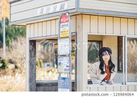 一名年輕女子在公車站等車 攝影由 Ugo Kotsu 提供。 一名年輕女子在公車站等車 攝影由 Ugo Kotsu 提供。 120984064