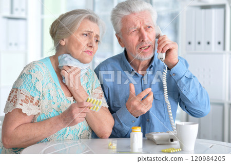 An elderly couple is sick and takes medication at home An elderly couple is sick and takes medication at home 120984205