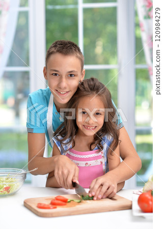 Cute little brother and sister preparing salad together at kitchen Cute little brother and sister preparing salad together at kitchen 120984279