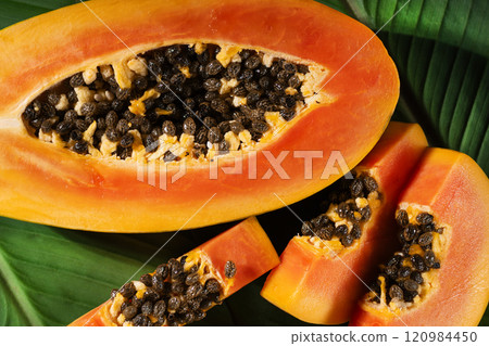 Juicy papaya fruit slices top view. Tropical papaya fruit background. Papaya fruit closeup. Juicy papaya fruit slices top view. Tropical papaya fruit background. Papaya fruit closeup. 120984450