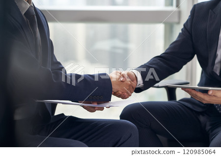 two asian businessmen shaking hands in office 120985064