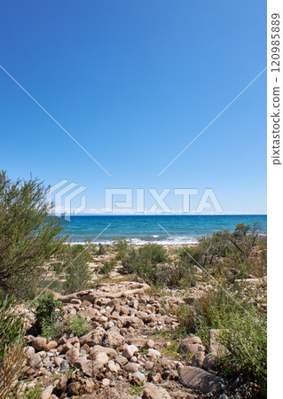 Wild beach, stone coast of southern shore of Lake Issyk-Kul, summer Kyrgyzstan 120985889