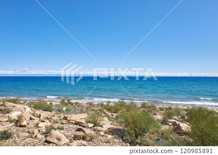 Stone coast of southern shore of Lake Issyk-Kul, summer vacation in Kyrgyzstan 120985891