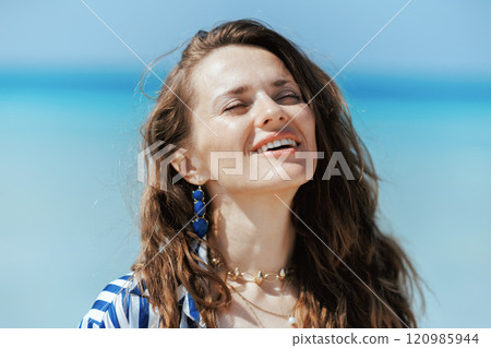 smiling modern female on seashore enjoying tranquility 120985944