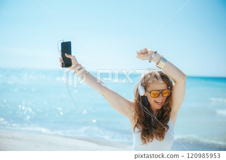 smiling elegant woman on seashore dancing 120985953