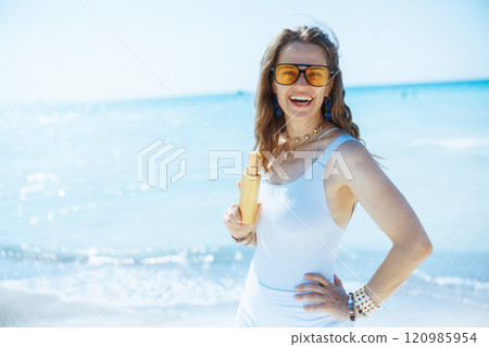 happy elegant woman on beach with spf happy elegant woman on beach with spf 120985954