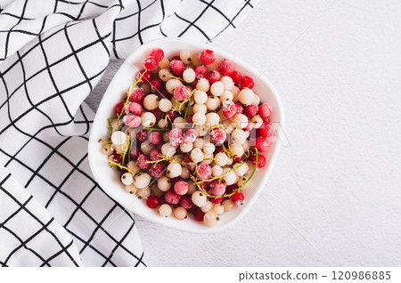 Close up of frozen red and white currants in bowl on table top view 120986885