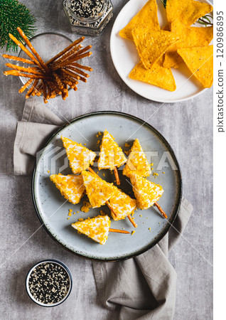 Christmas trees made of cheese and nachos on a plate on a table top and vertical view Christmas trees made of cheese and nachos on a plate on a table top and vertical view 120986895