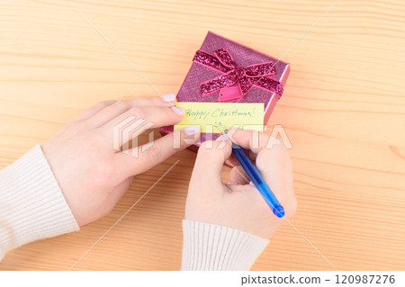Yellow handwritten note Happy Christmas on a gift box. 120987276
