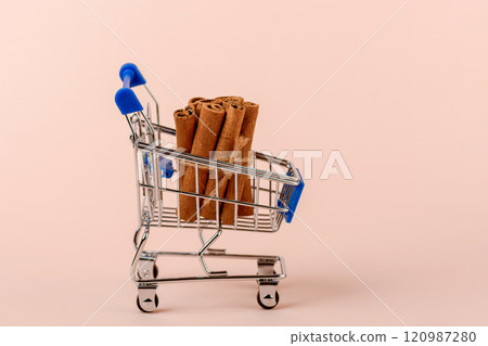 A bunch of cassia spices in a toy shopping cart. 120987280