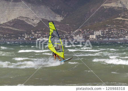 A kite surfer rides and jumps the waves the black sea A kite surfer rides and jumps the waves the black sea 120988318