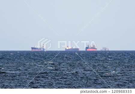 Sea freighter sailing in the middle of the ocean with big waves Sea freighter sailing in the middle of the ocean with big waves 120988333