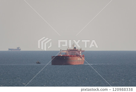Sea freighter sailing in the middle of the ocean with big waves Sea freighter sailing in the middle of the ocean with big waves 120988338