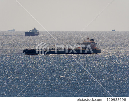 Sea freighter sailing in the middle of the ocean with big waves Sea freighter sailing in the middle of the ocean with big waves 120988696