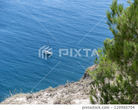 Boat in the middle of the sea sails alone among the waves to the horizon on a late summer day 120988704