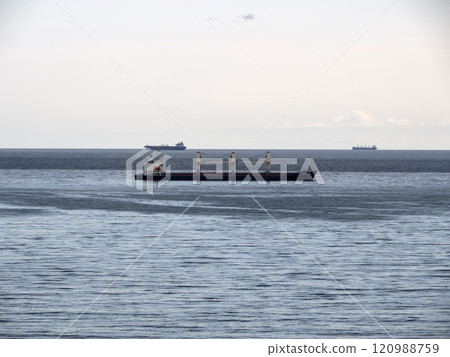 Sea freighter sailing in the middle of the ocean with big waves Sea freighter sailing in the middle of the ocean with big waves 120988759