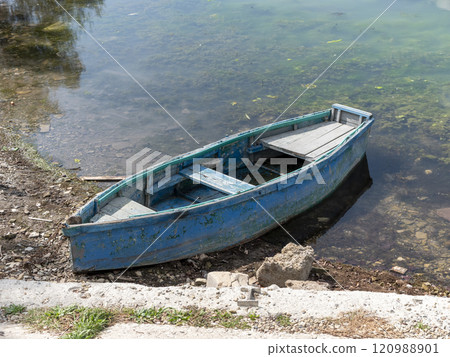 Small wooden boats of multiple colors moored on the shore of Lake Abrau 120988901