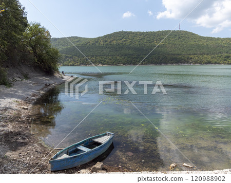 Small wooden boats of multiple colors moored on the shore of Lake Abrau Small wooden boats of multiple colors moored on the shore of Lake Abrau 120988902