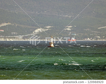 Novorossiysk, Russia 28 August 2024 Bulk carrier and lighthouse in the port in the Black Sea coast 120988920
