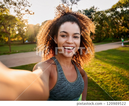 Young Woman Taking a Candid Selfie at Golden Hour in a Park 120989522