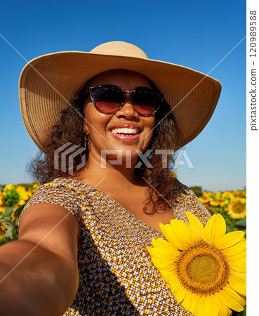 Happy Plus-Size Woman Taking a Selfie in a Sunflower Field Happy Plus-Size Woman Taking a Selfie in a Sunflower Field 120989588