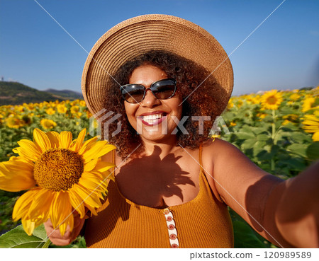 Happy Plus-Size Woman Taking a Selfie in a Sunflower Field 120989589