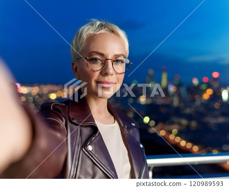 Stylish Non-Binary Person Taking a Nighttime Rooftop Selfie 120989593