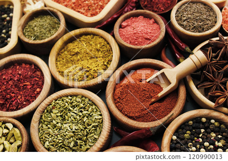 Colorful mix of herb and spice varieties: curry and coriander, turmeric and cumin, paprika and pepper, mustard and salt, cardamon and oregano and saffron. Selective focus, shallow DOF 120990013