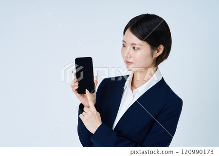 A woman in a suit operating a smartphone 120990173
