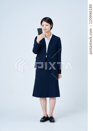 A woman in a suit operating a smartphone A woman in a suit operating a smartphone 120990180