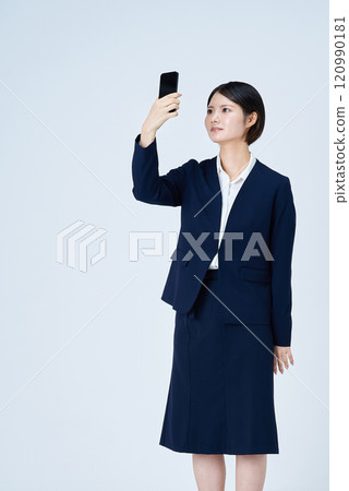 A woman in a suit operating a smartphone A woman in a suit operating a smartphone 120990181