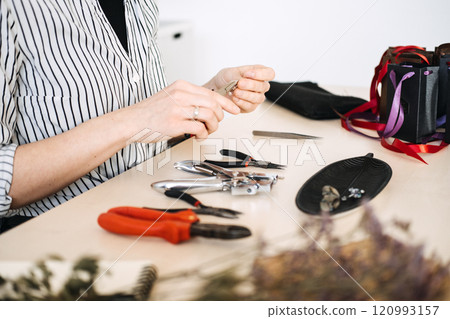 Artisan crafting workspace with jewelry-making tools. Highlighting professional craftsmanship and the essentials of handmade creativity. Artisan crafting workspace with jewelry-making tools. Highlighting professional craftsmanship and the essentials of handmade creativity. 120993157